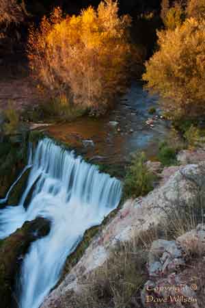 A waterfall flows over the old dam on Fossil Creek, Arizona in autumn