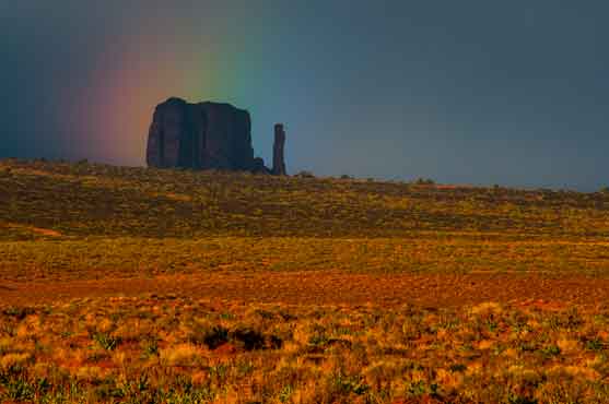 A rainbow hovers over West Mitten Butte at Monument Valley on the Navajo Nation in northern Arizona